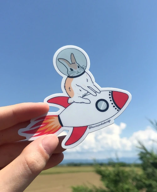 Sticker illustrato reale di un coniglio astronauta su un razzo