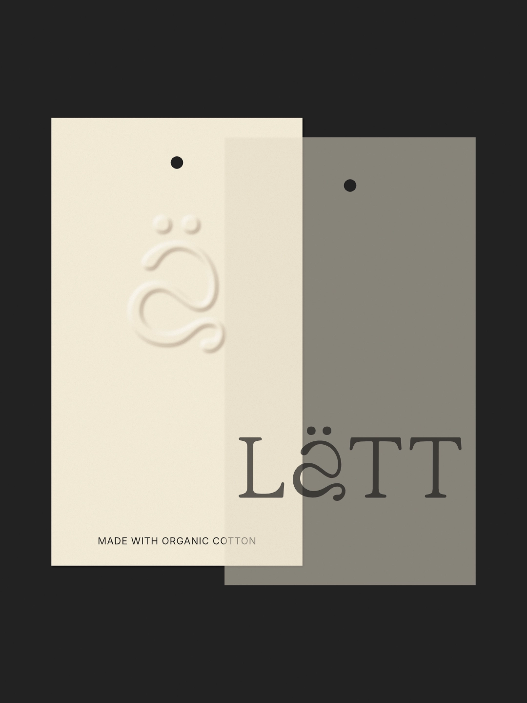 Primo piano dei cartellini Lätt: uno in cartoncino color crema con logo in rilievo, l'altro in materiale traslucido grigio con il logo nero, a evidenziare i materiali premium.