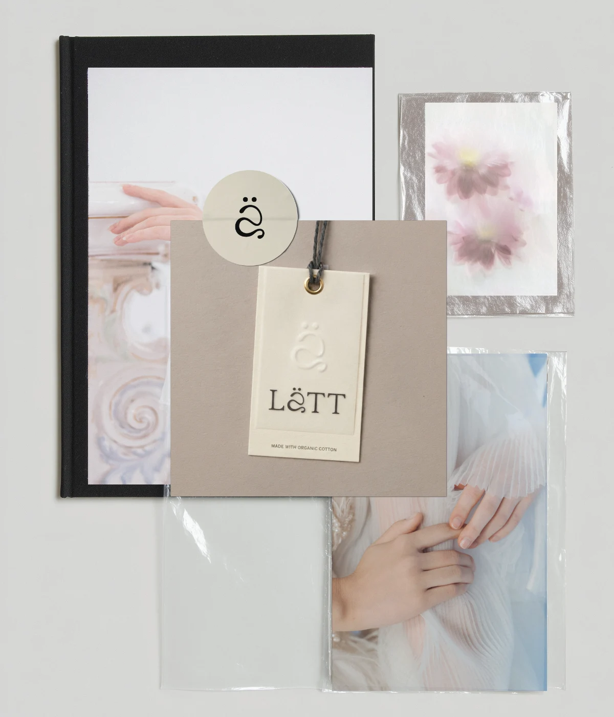 Insieme di materiali di presentazione Lätt: cartellini in cotone organico, un quaderno nero e stampe artistiche con i fiori del moodboard, confezionati in modo elegante e naturale.